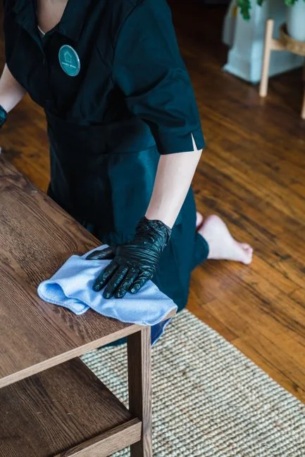 A hotel employee holding towels in a luxury bathroom with elegant decor.